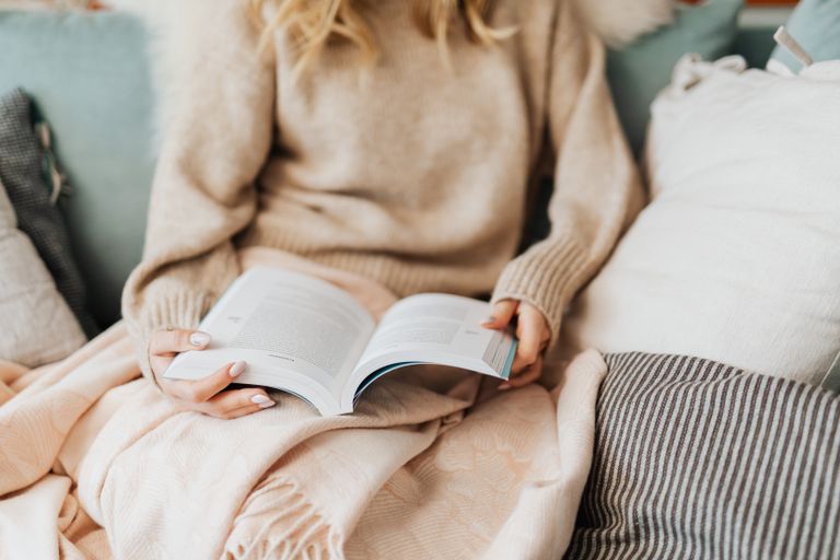 Lezer met een open boek op de bank